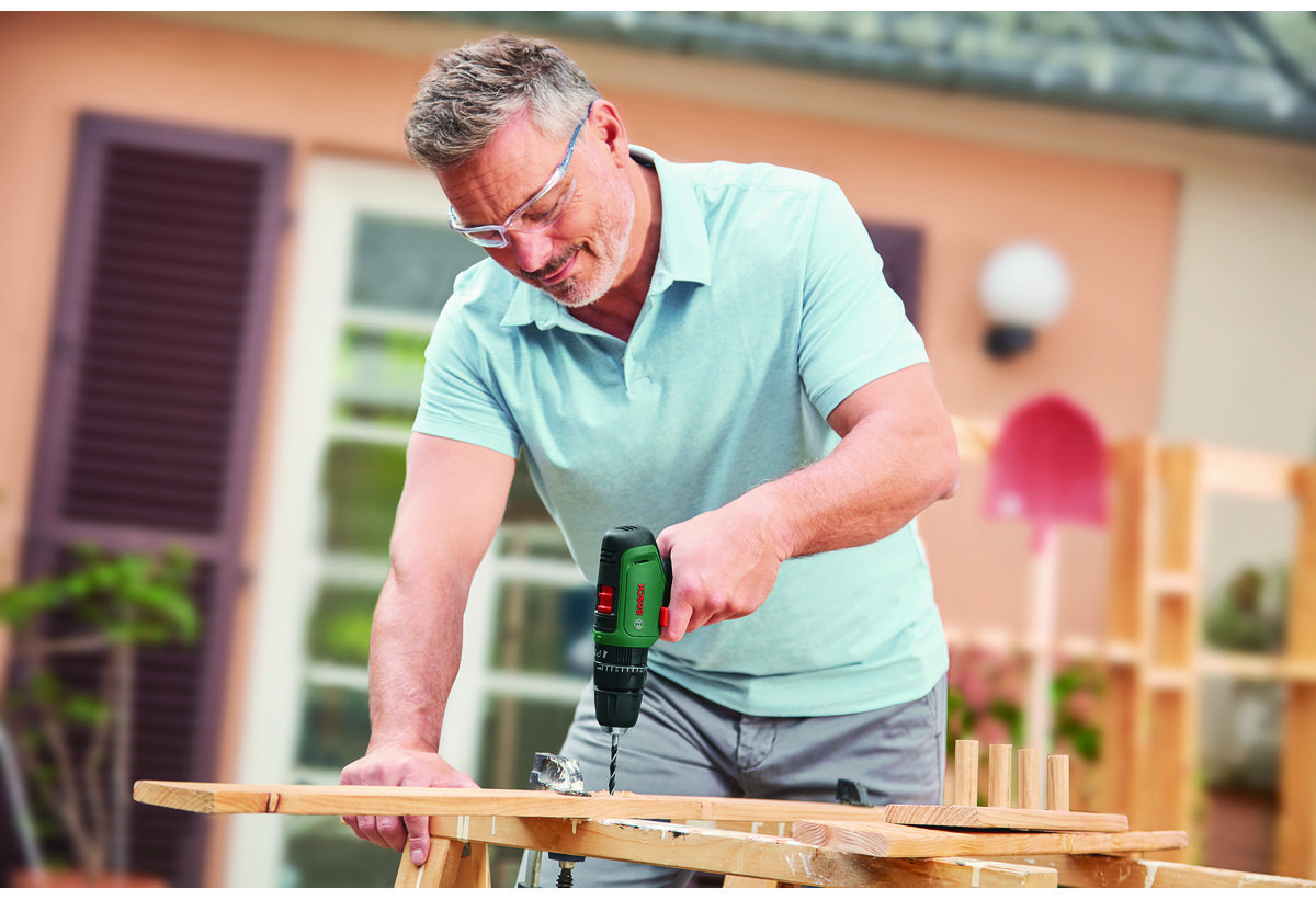 Ένας άντρας χρησιμοποιεί το δραπανοκατσάβιδο σε μία ξύλινη επιφάνεια.